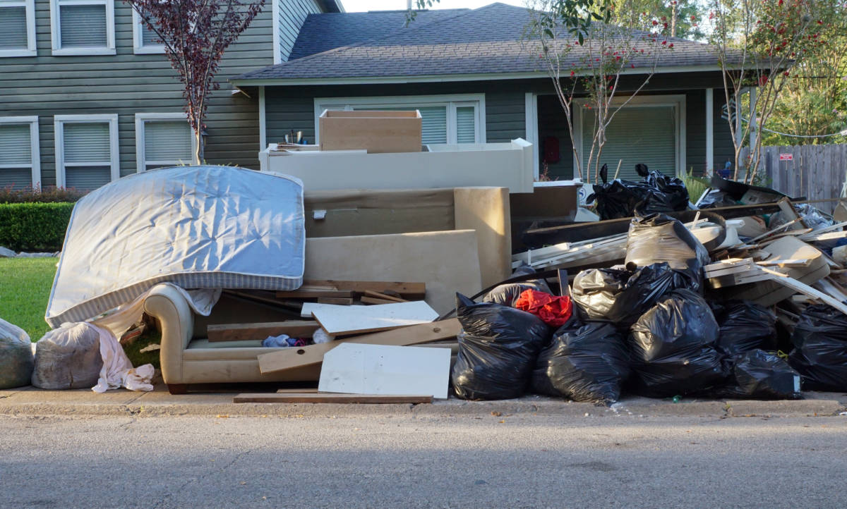 pile of junk outside of home on sidewalk to be hauled away